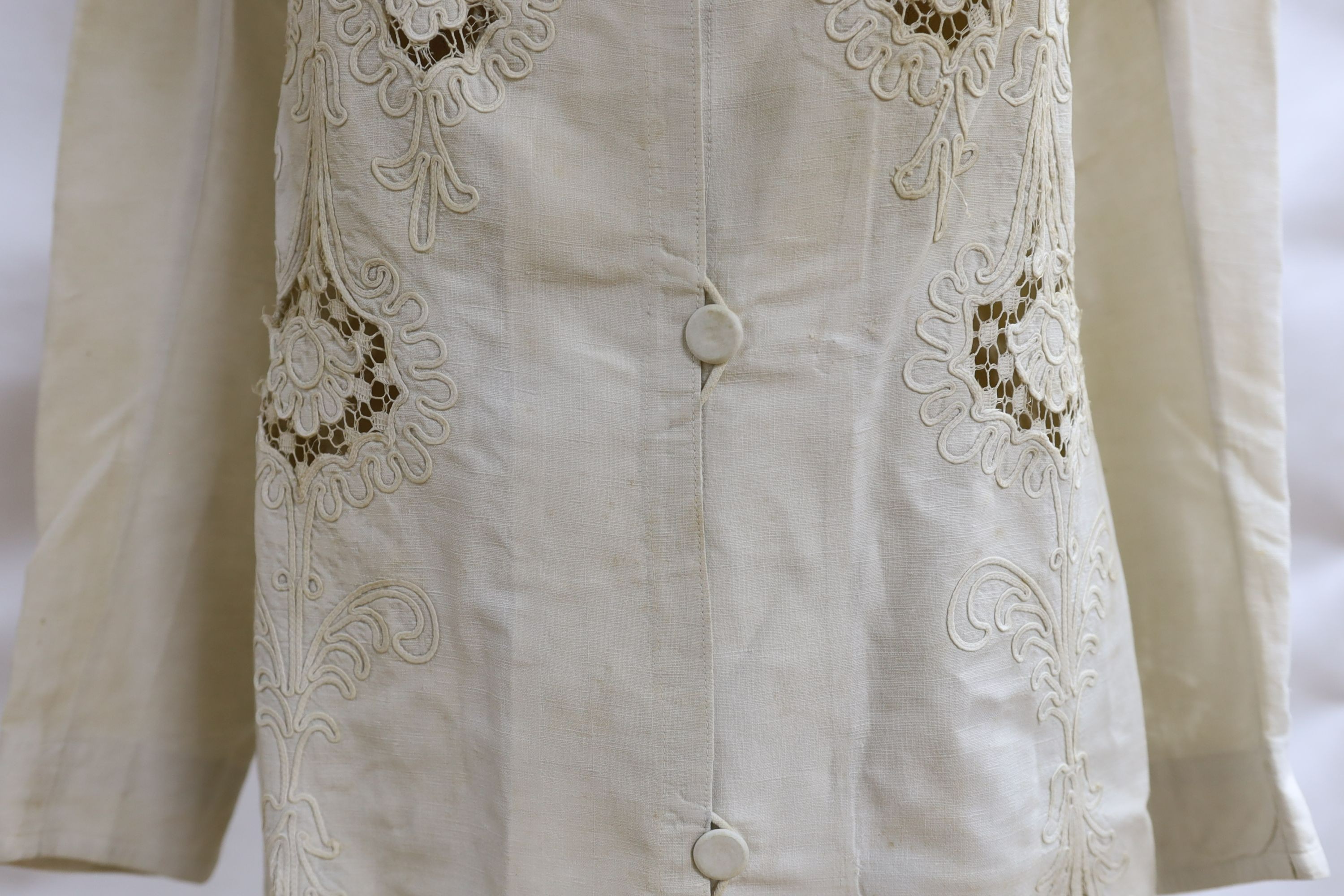 An Edwardian white/cream linen lady's coat with cut work detail and unusual button detail to the back